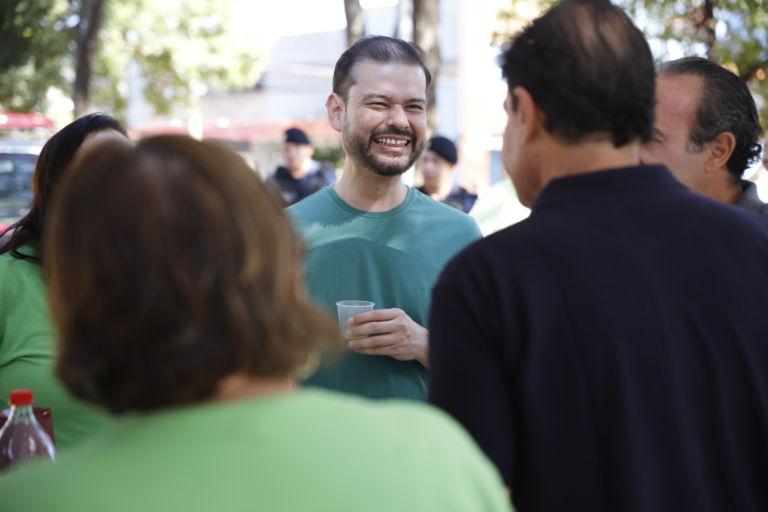 Alessandro Hirata rindo em conversa com moradores num evento de rua